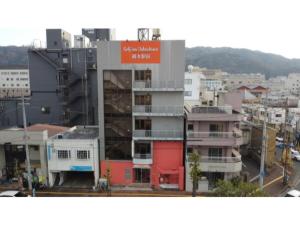 a building with a red sign on it in a city at Self inn Tokushima kuramoto ekimae - Vacation STAY 19485v in Tokushima
