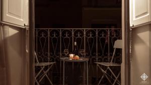 una mesa con una botella de vino en el balcón en LE 4 PERLE Apartments, en Avola
