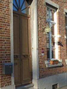 a brick building with a wooden door and a window at Guesthouse Alizée in Leuven