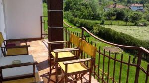 a balcony with two chairs and a view of a field at Къща за гости "Край Реките" in Apriltsi