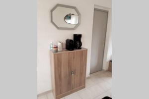 a bathroom with a mirror and a wooden cabinet at Appartement calme Entre Terre et Mer proche plage in Fleury