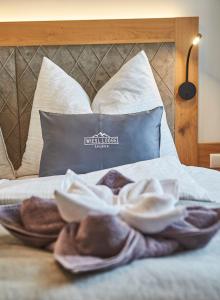 a bed with towels on it with a pillow at Wiesl Lodge Saalbach in Saalbach Hinterglemm