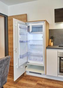 an empty refrigerator with its door open in a kitchen at Wiesl Lodge Saalbach in Saalbach Hinterglemm