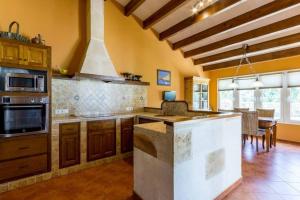 a kitchen with a stove top oven next to a table at Chalet Signe Cranc in Sa Caleta
