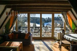 ein Wohnzimmer mit einem großen Fenster mit Bergblick in der Unterkunft Haus 4-Jahreszeiten in Siegsdorf