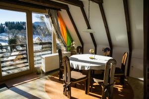 ein Esszimmer mit einem Tisch und Stühlen sowie einem großen Fenster in der Unterkunft Haus 4-Jahreszeiten in Siegsdorf