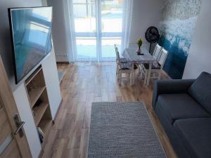 a living room with a table and a couch and a television at Apartament Sun&Fun - Rowy in Rowy