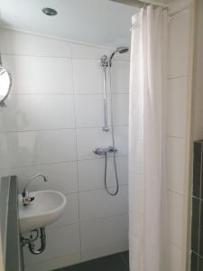 a bathroom with a shower curtain and a sink at Little Lodge Noordwijk aan Zee in Noordwijk