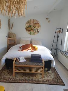 a bedroom with a bed with a table on it at Little Lodge Noordwijk aan Zee in Noordwijk