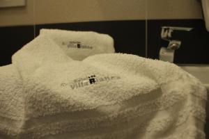 a pile of white towels on a bathroom sink at Hotel Villa Bianca in San Salvo