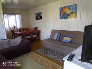 ein Wohnzimmer mit einem Sofa und einem Esszimmer in der Unterkunft Casa de Praia. Lugar sossegado para recarregar as energias. in Passo de Torres