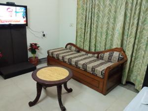 a small bed with a stool and a table at Gardenia 29 in Raichak