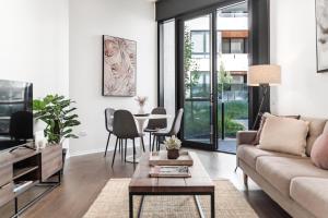 a living room with a couch and a table at Kerridge St Apartments by Urban Rest in Kingston 