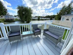 een terras met twee stoelen en uitzicht op het water bij Lilly Pad in South Cerney