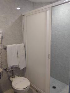 een badkamer met een toilet en een douche met handdoeken bij Hotel Cuba in Mexico-Stad