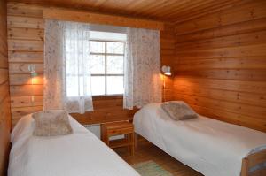 a bedroom with two beds and a window at Rinnepelto Holiday Cottages in Tahkovuori