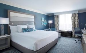 Habitación de hotel con cama grande y escritorio. en Rosen Centre Hotel Orlando Convention Center en Orlando