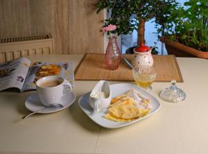 斯摩棱斯克的住宿－Barin Hotel，一张桌子,上面放着一盘煎饼和一杯咖啡
