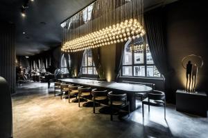 ein Esszimmer mit Tisch, Stühlen und Kronleuchter in der Unterkunft Black Hotels Köln in Köln