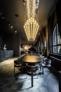 a dining room with a table and chairs and a chandelier at Black Hotels Köln in Cologne