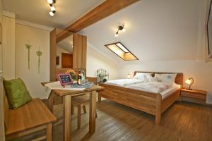 a bedroom with a bed and a table and a chair at Stöcklhof in Siegsdorf