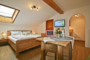 a bedroom with a bed and a table in it at Stöcklhof in Siegsdorf