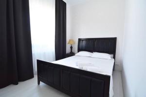 ママイア・ノルドにあるImperia by Zev Apartmentsのベッドルーム(白いシーツを使用した大きな黒いベッド付)