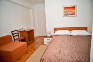 1 dormitorio con 1 cama grande y 1 silla en El Mirador Rooms with Balcony, en Zadar