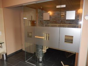 a glass shower in a bathroom with a tile floor at Gîte du Moulin - Rose in Trois-Ponts