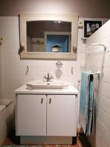 a white bathroom with a sink and a mirror at L'autre rive de la Tourelle in Ways