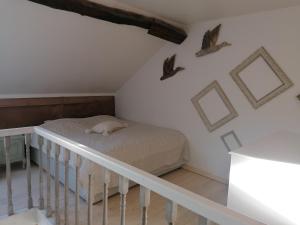 ein Schlafzimmer mit einem Bett und Vögeln an der Wand in der Unterkunft L'autre rive de la Tourelle in Ways