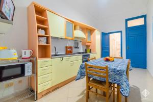 a kitchen with yellow cabinets and a table at LE 4 PERLE Apartments in Avola