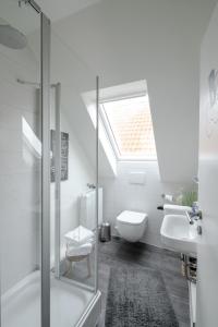 a bathroom with a skylight and a toilet and a sink at Gästehaus Von Herzen in Lauenburg