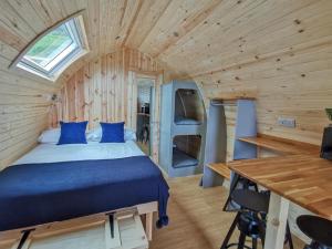 a bedroom with a bed in a wooden cabin at The Huts at Highside Farm in Keswick