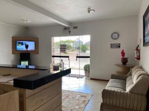a living room with a couch and a tv in it at Pousada Fuzer in Restinga Sêca