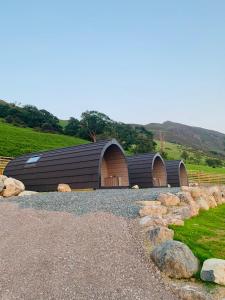 a black building with two brown doors and rocks at The Huts at Highside Farm in Keswick