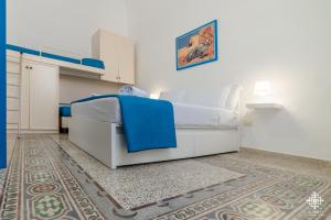 1 dormitorio con cama blanca y alfombra en LE 4 PERLE Apartments, en Avola
