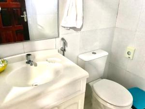 a white bathroom with a toilet and a sink at Jungle Spa e Hotel in Rio Preto Da Eva