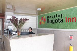 un hombre sentado en un escritorio en una oficina en Hoteles Bogotá Inn Galerías, en Bogotá