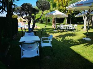 een groep tafels en stoelen met parasols bij Hostal Al-Andalus in La Guijarrosa