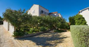 a house with a row of trees in a driveway at Villa Lukrecia - Stone Villa with Pool & Sea Views I Supetar, Brač in Supetar