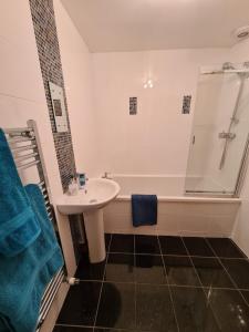 a bathroom with a tub and a sink and a shower at The Editor's Choice, Oban seafront apartment in Oban