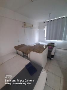 a small room with a bed and a table at Flats Bueno em Goiânia in Goiânia
