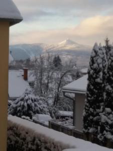 una casa con vistas a una montaña nevada en Apartmán Formanka, en Liberec