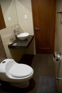 a bathroom with a white toilet and a sink at Hotel Central in Trujillo