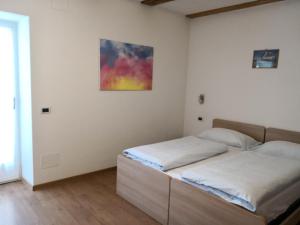 a bedroom with two beds and a painting on the wall at Apartment Irsara in Arabba
