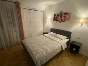 a small bedroom with a bed and two lamps at Center Loft in Buzău