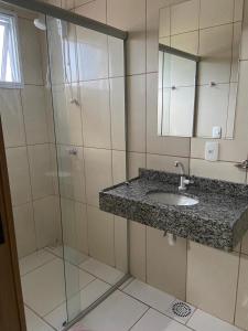 a bathroom with a sink and a glass shower at Pousada Fuzer in Restinga Sêca