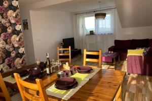 una sala da pranzo con tavolo in legno e un soggiorno di Apartament - Strefa Relaksu a Nowy Targ