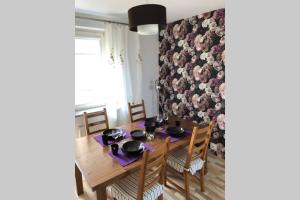 una sala da pranzo con tavolo e sedie e una parete floreale di Apartament - Strefa Relaksu a Nowy Targ Altre 24 foto